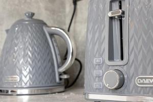 a tea kettle is next to a toaster on a counter at Spacious 3-Bed Apartment, Alva, Clackmannanshire in Alva
