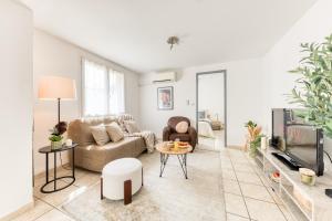 a living room with a couch and a tv at Cocon lumineux au centre de Tarbes, terrasse privée au soleil, confort tout inclus in Tarbes