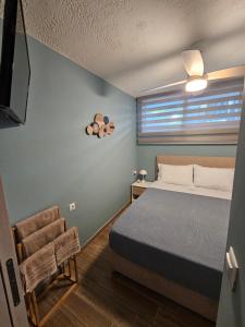 a bedroom with a bed and a window and a chair at Calma Resort in Skala Fourkas