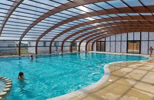a large swimming pool with people in the water at Mobilhome camping St jacques in Sarzeau
