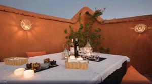 a table with bottles of wine and candles on it at Riad Rossi in Marrakesh