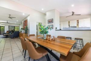 a dining room and living room with a wooden table and chairs at Huge Stylish Townhouse in Stuart Park