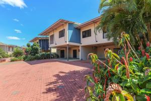 a house with a palm tree and a brick driveway at Huge Stylish Townhouse in Stuart Park