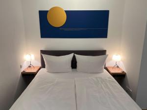 a bedroom with a bed with two lamps on two tables at FirstClass Apartments in Hamburg