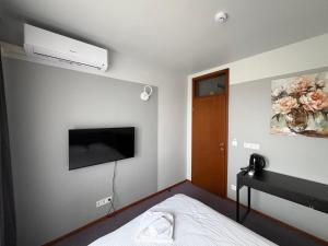 a bedroom with a bed and a tv on the wall at Hotel Vento in Ventspils