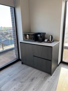 a kitchen with a microwave on a counter with a large window at Bavaro apartments 4 in Ivano-Frankivsk