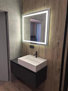 a bathroom with a white sink and a mirror at Bavaro apartments 4 in Ivano-Frankivsk