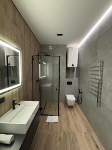 a bathroom with a sink and a shower and a toilet at Bavaro apartments 4 in Ivano-Frankivsk +9 photos