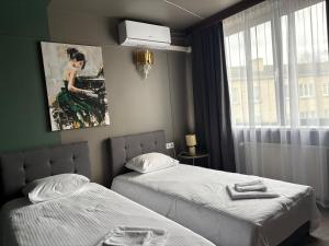 a hotel room with two beds and a window at Hotel Vento in Ventspils