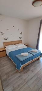 a bedroom with a bed with two towels on it at Pansion Maria in Zadar