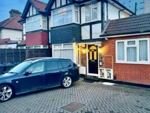 a blue car parked in front of a house at Spacious Double Room with own Sink in Colindale