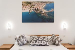 a white couch with pillows and a picture on the wall at Dimora dei Cedri in Santa Maria del Cedro