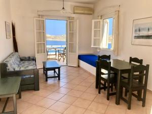 a living room with a couch and a table and chairs at Agios Pavlos Studios in Aegiali +36 photos