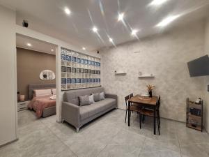 a bedroom with a couch and a bed and a table at Casa vacanze al teatro in Catania