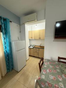 a small kitchen with a refrigerator and a table at Vila Katerina Qeparo in Qeparo