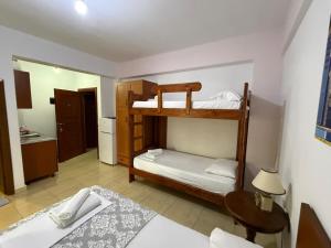 two bunk beds in a room with a table and a bed at Vila Katerina Qeparo in Qeparo