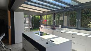 a kitchen with white cabinets and a blue ceiling at Maison de village in Copponex