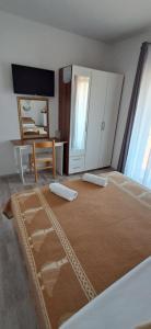 a bedroom with a bed and a desk and a television at Pansion Maria in Zadar