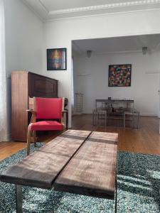 a living room with a red chair and a table at LE GATSBY, appartement ART DECO 4 pers, plage et hyper centre in Le Havre