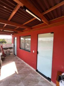 a garage with red walls and a red door at Cerrado da Canastra Chalé Quartinho simples in São Roque de Minas