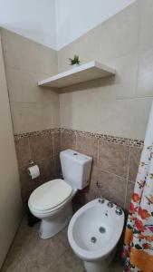 a bathroom with a white toilet and a sink at Depto Baires Oeste Merlo in Merlo