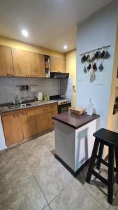 a kitchen with wooden cabinets and a counter top at Depto Baires Oeste Merlo in Merlo