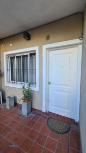 a room with a door and a potted plant at Depto Baires Oeste Merlo in Merlo