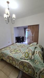 a bedroom with a bed with a colorful bedspread at Depto Baires Oeste Merlo in Merlo
