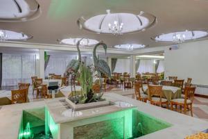 a dining room with tables and chairs and a large room with tables and chairs at Hotel Shipka All Inclusive in Golden Sands