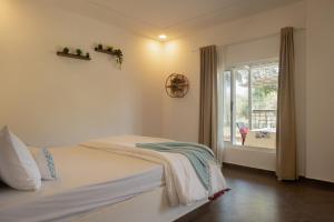 a bedroom with a bed and a window at Amra Woods in Karjat