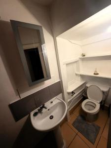 a bathroom with a sink and a toilet and a mirror at Spacious Double Room with own Sink in Colindale