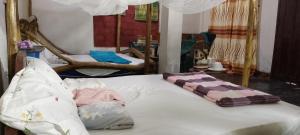a bed with white sheets and a blanket on it at Antique Lodge in Arusha