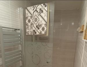 a shower with a glass door and a mirror at apartement avec parking prive in Concarneau +20 photos