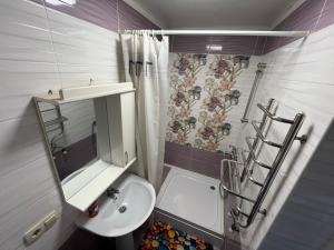 a bathroom with a sink and a toilet and a shower at Садиба "У Пані Галини" з форельним господарством in Kosiv +57 photos