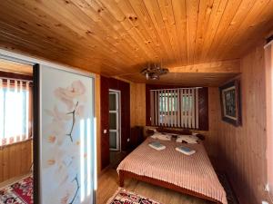 a bedroom with a bed in a wooden room at Садиба "У Пані Галини" з форельним господарством in Kosiv