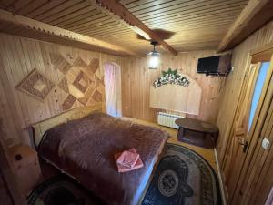 a bedroom with a bed in a wooden room at Садиба "У Пані Галини" з форельним господарством in Kosiv