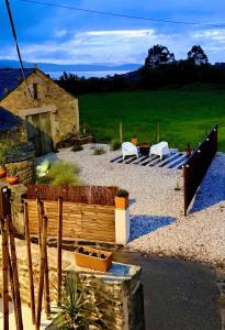 a garden with two white chairs and a wooden fence at The Cliffs - PradaBeach in Jove