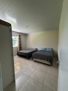 two beds in a room with a door open at Chácara com piscina, lazer e muita natureza in Morretes +7 photos