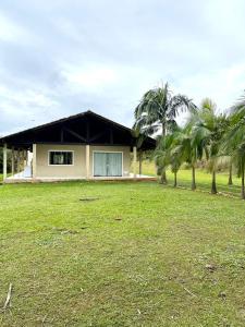 a house with palm trees in front of it at Chácara com piscina, lazer e muita natureza in Morretes