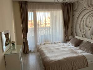 a bedroom with a large bed and a window at Joy Escape Varna in Varna City