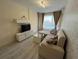 a living room with a couch and a tv at Joy Escape Varna in Varna City