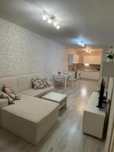 a living room with a couch and a table and a kitchen at Joy Escape Varna in Varna City