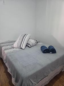 a bed with two blue slippers on top of it at Aconchego in Concordia