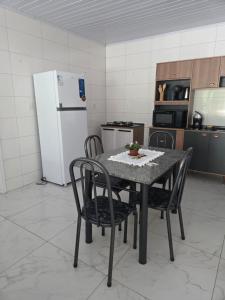 a kitchen with a table and chairs and a refrigerator at Aconchego in Concordia +5 photos