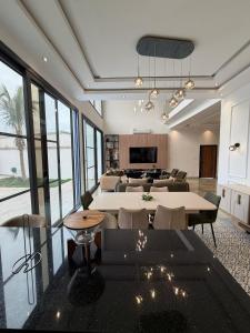 a large living room with tables and chairs and a living room at La villa Bella Vista in Somone