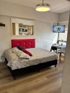 a bedroom with a bed with a red headboard and a table at Torre Obelisco - Apart 2 Amb en Av Corrientes, Buenos Aires, Argentina in Buenos Aires