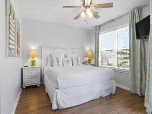a white bedroom with a bed and a ceiling fan at Beachside Villas #821 - Dreamweaver in Seagrove Beach