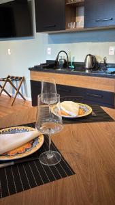 a table with plates of food and a glass of wine at Residencial Zoe 101 in Foz do Iguaçu