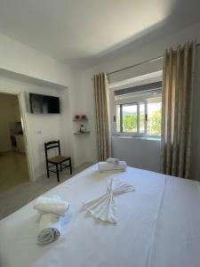 a white bed with two towels on top of it at eljos house permet in Përmet