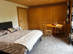 a bedroom with a bed and a table and chairs at Le cocon alpin in Passy